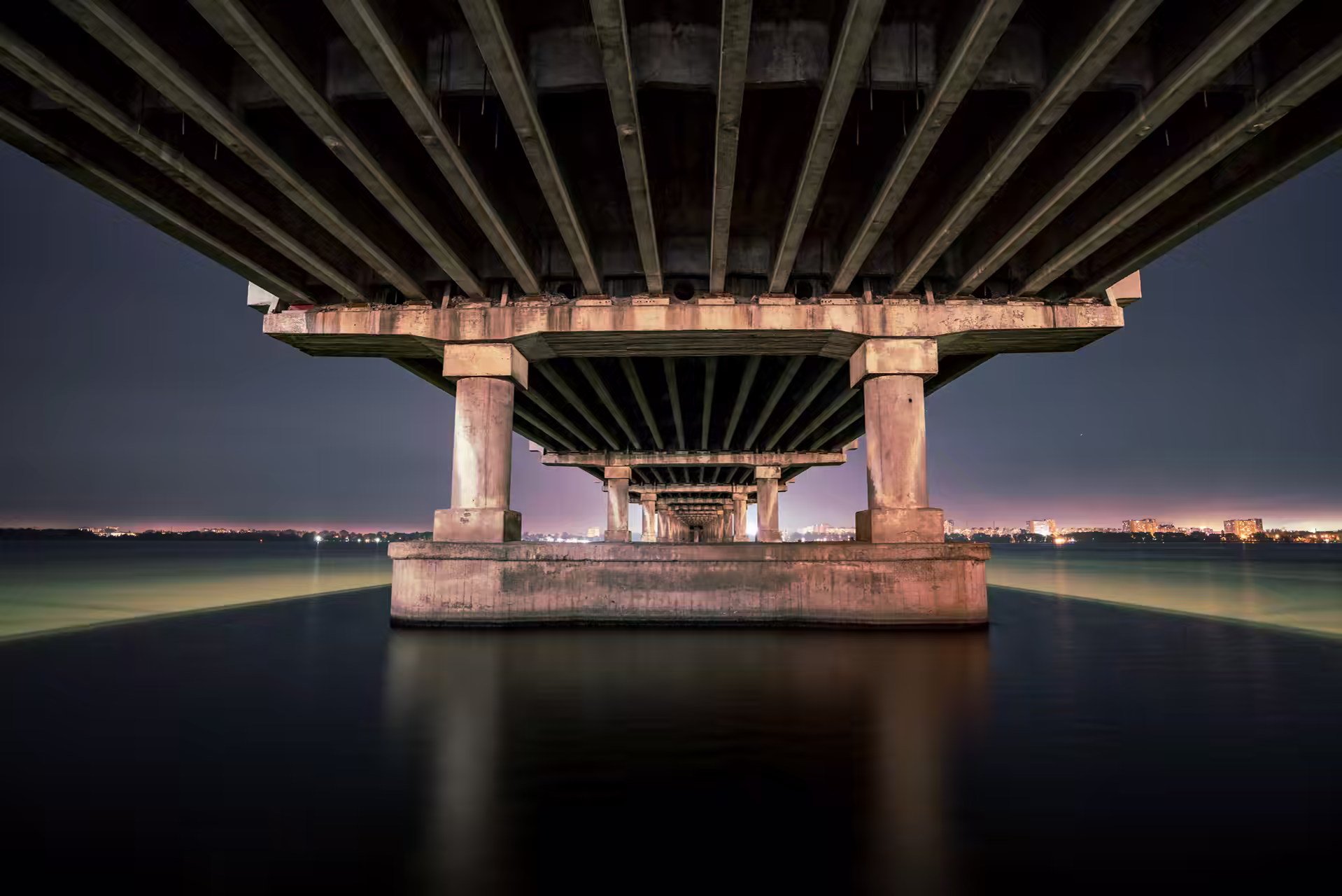 Steel truss bridge span photographed along the deck at dusk